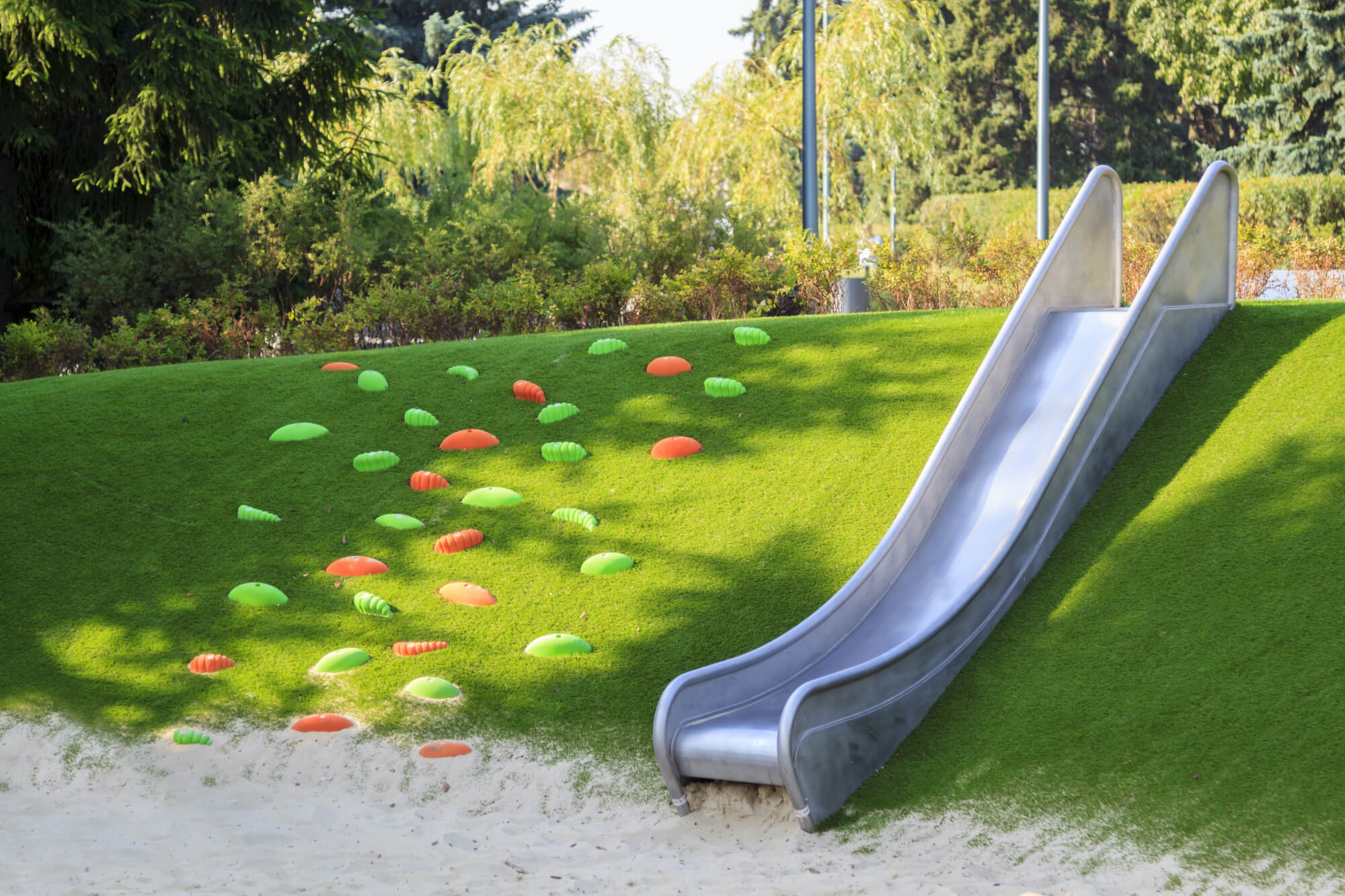playground-grass-slide Metal slide placed on artificial grass